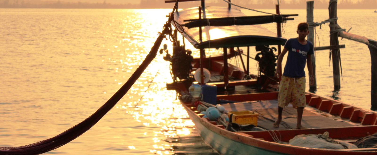 A local fisherman prepares a boat for a group of volunteers on a trip to experience Khmer cultural immersion. 