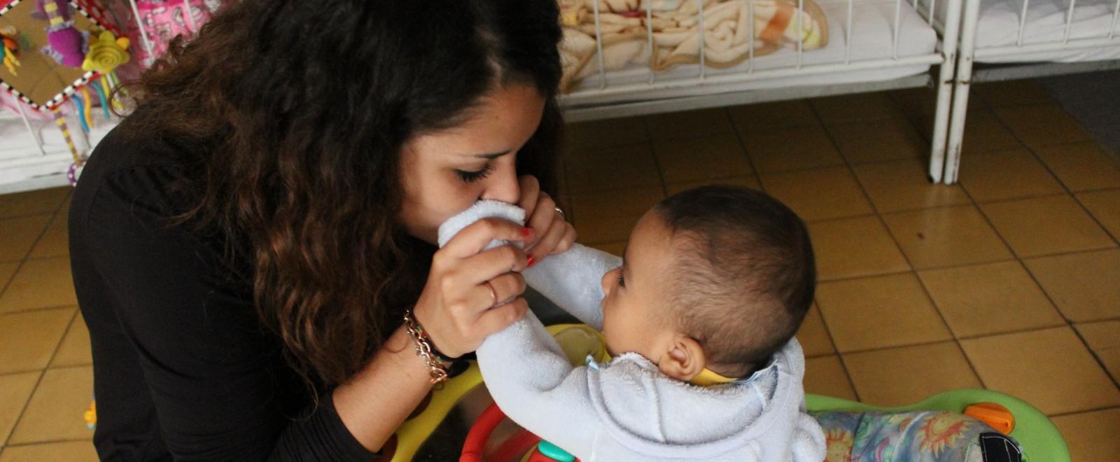 Projects Abroad volunteer working with children in Mexico cares for a baby at a care centre for children from working families. 