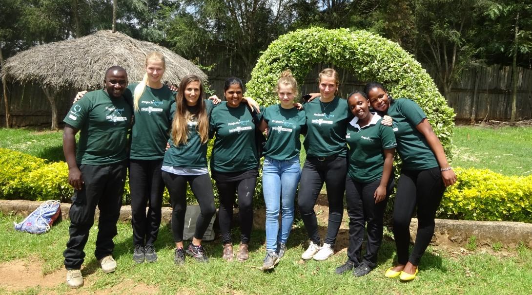 A group of Childcare volunteers working with children in Kenya pose for a photo before they start a community day event. 