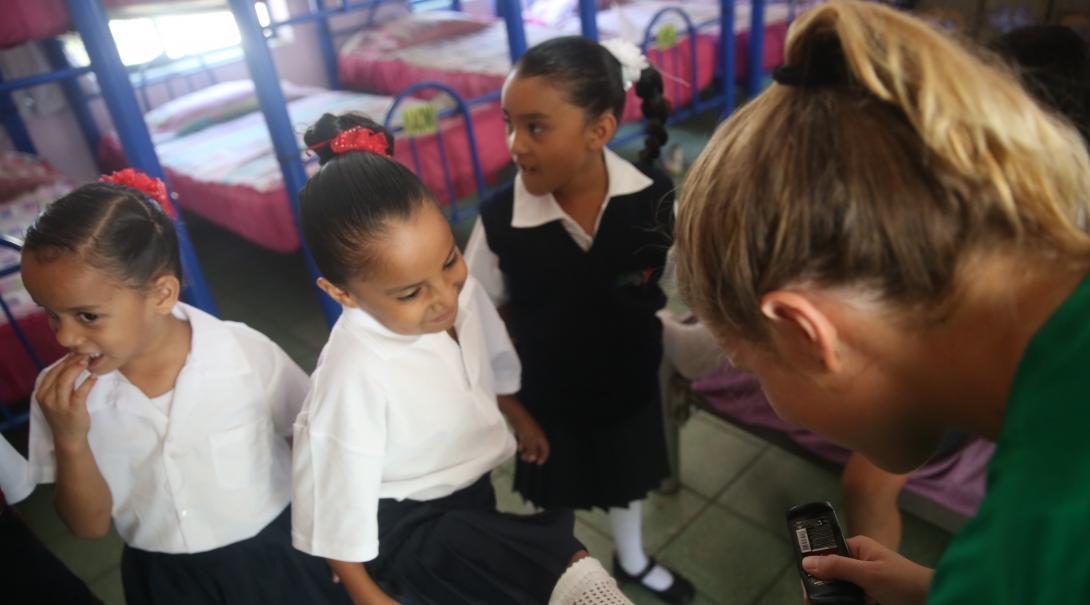 Projects Abroad volunteer working with children in Mexico polishes a young girl's shoes at her Childcare placement.