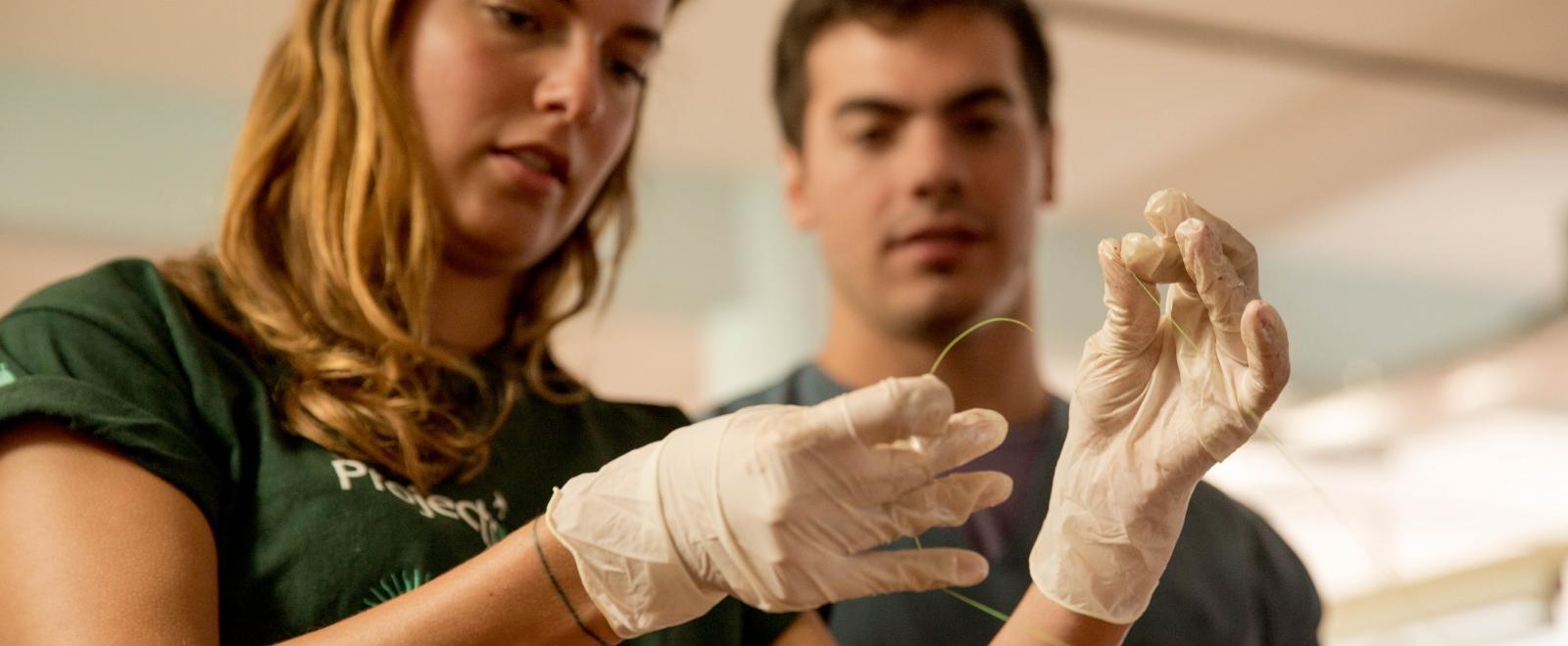 Female Projects Abroad Medicine intern learns how to tie a sature at a hopsital as part of her medical work experience in Argentina. 