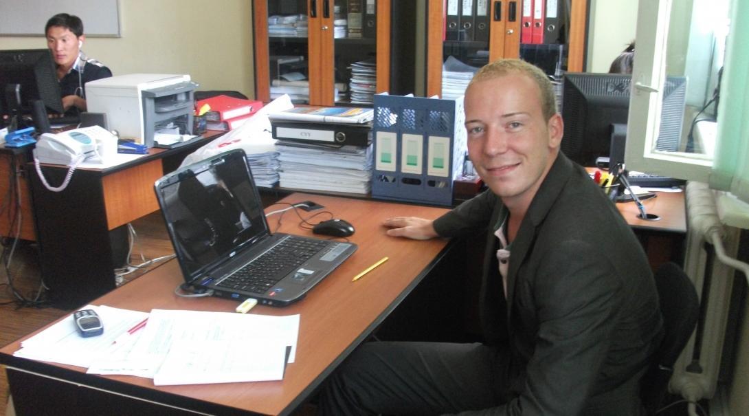 Business Intern poses for a picture at his administration desk during his Business Internship in Mongolia. 