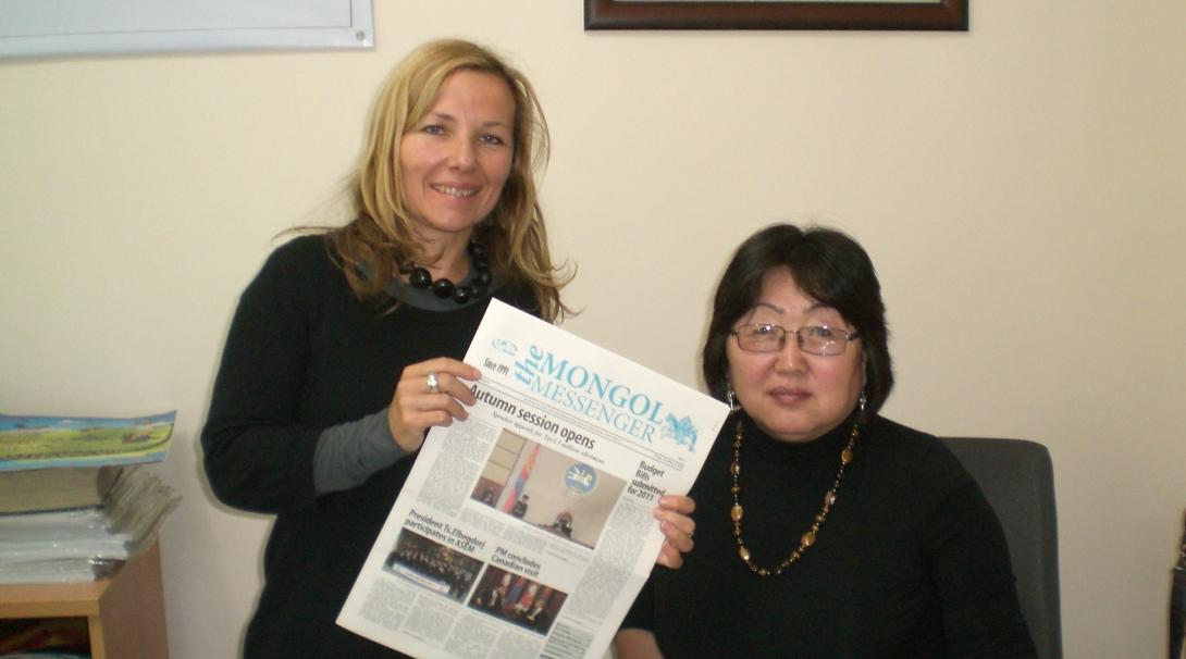 An interns holds up a magazine at her placement in Mongolia 