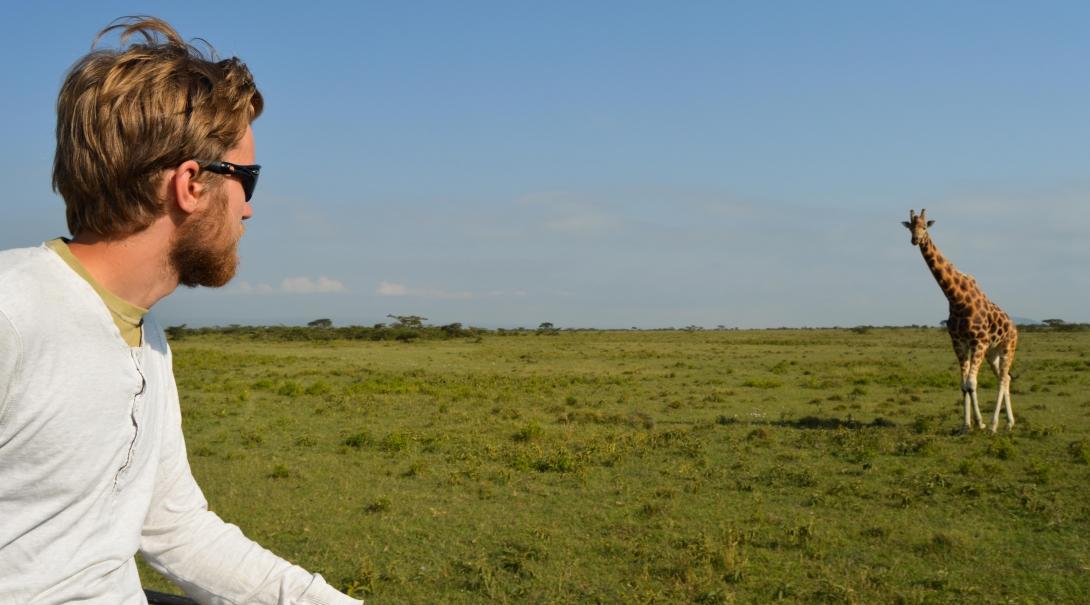 A male Projects Abroad volunteer spots a male giraffe whilst out and taking part in his Wildlife conservation volunteer work in Kenya.