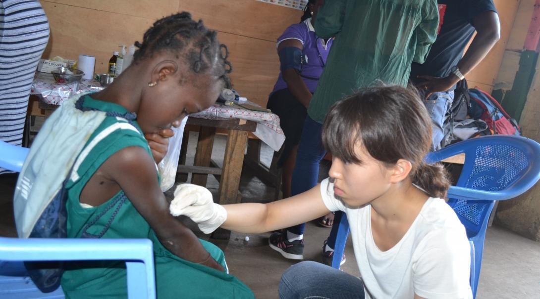 An intern gains medical work experience cleaning a wound on our project for teenagers in Ghana