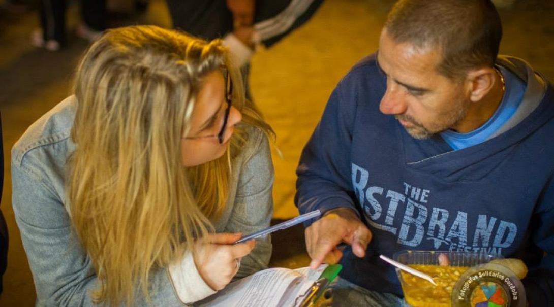 A student assists a homeless man during her Human Rights internships in Argentina.