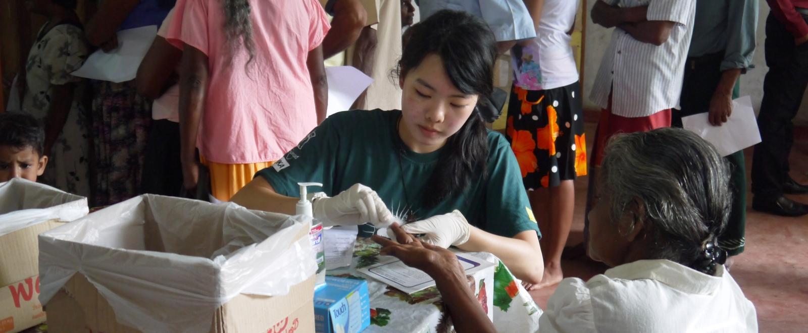 Projects Abroad intern assists with testing blood pressure and sugar levels in Sri Lanka whilst on her medical placement.