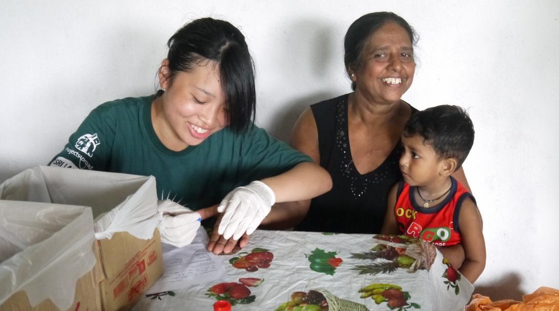 A female health care student is seen taking blood pressure and sugar levels ina . local surgery as part of her nursing internship in Sri Lanka with Projects Abroad.