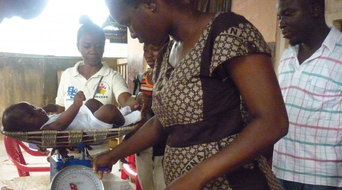 Projects Abroad students undertaking Midwifery internships in Ghana observing local doctors whilst performing a check up on a baby.