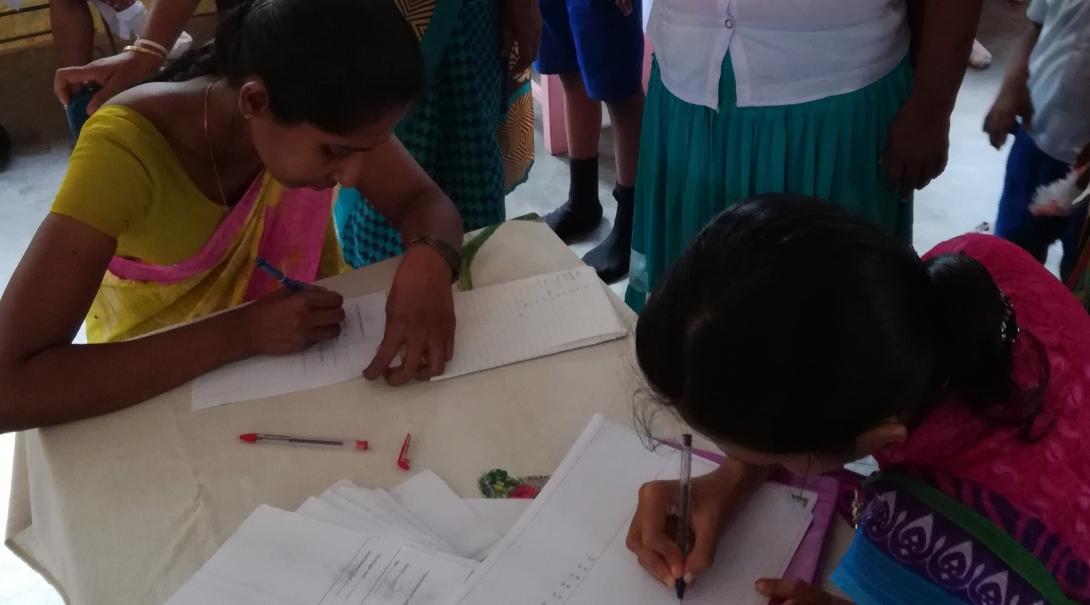 Local Sri Lankan women provide their details for medical staff at an outreach organised and run by Projects Abroad.