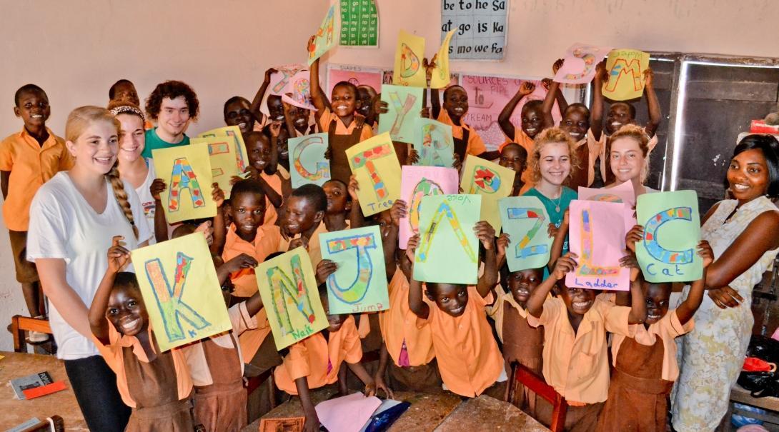 Projects Abroad volunteers take a group photo with their students during their teaching work experience in Ghana