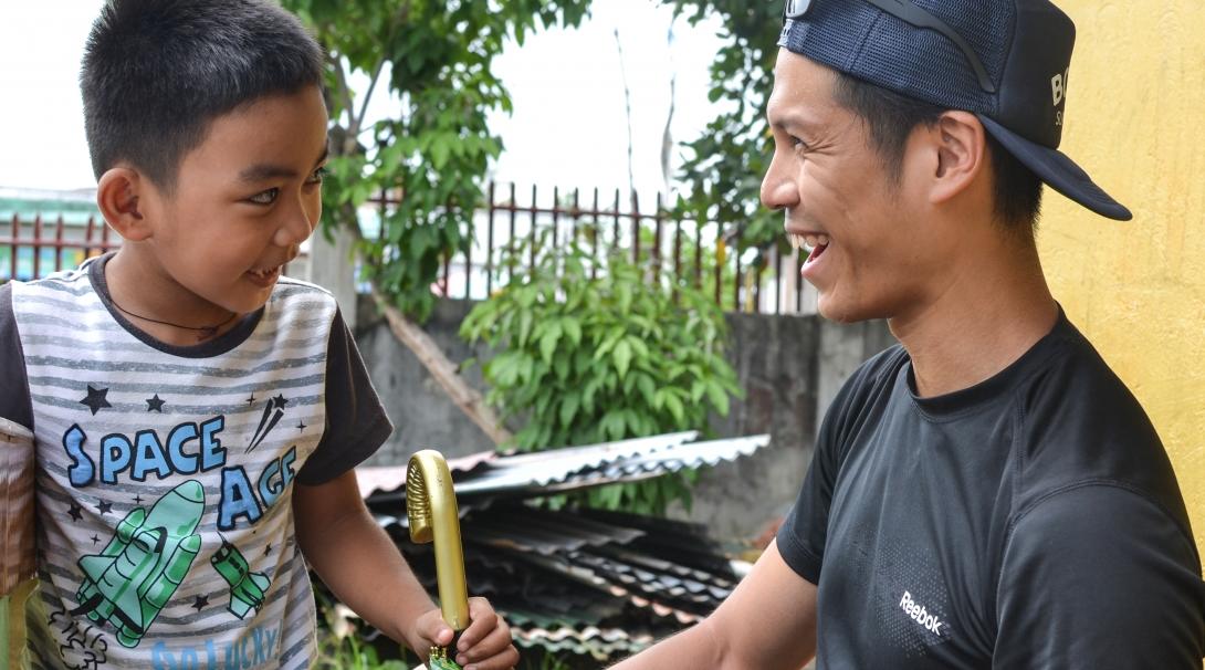 A Projects Abroad male intern is pictured having fun with a local child whilst on his physiotherapy internship in the Phillippines.