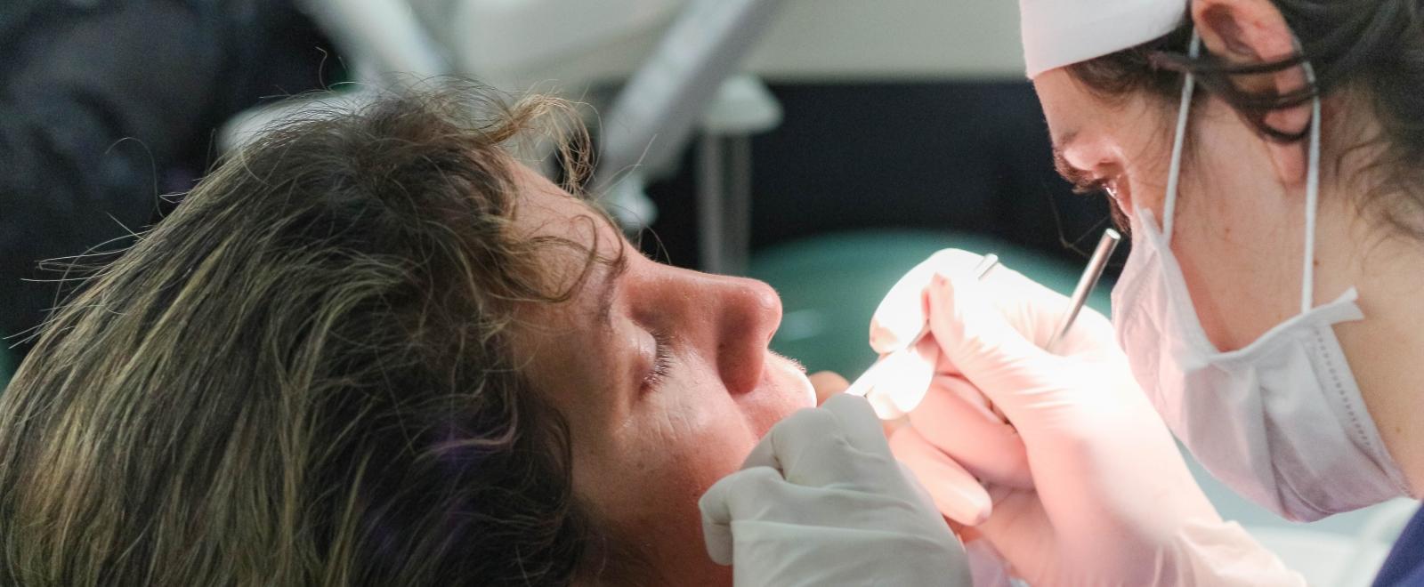 A local dentist treats a patient in Argentina as Projects Abroad dental interns observe for their Dentistry internship