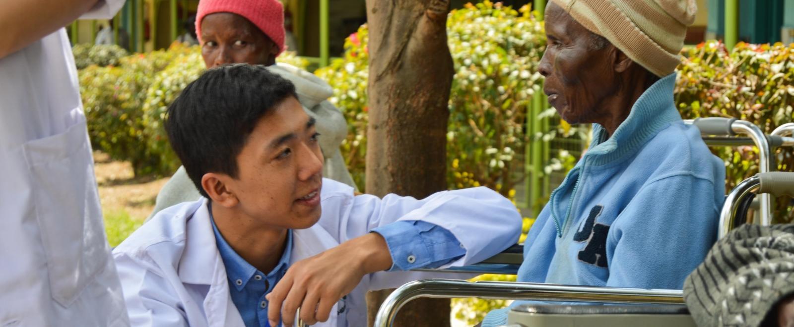 An intern working with a patient on our medical internship for teenagers in Kenya