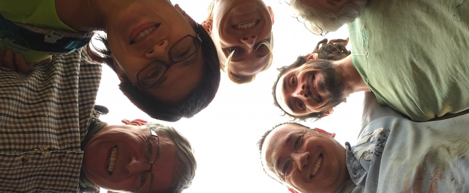 A group of volunteers over 50 doing childcare volunteering in Nepal, take a photo outside their placement. 