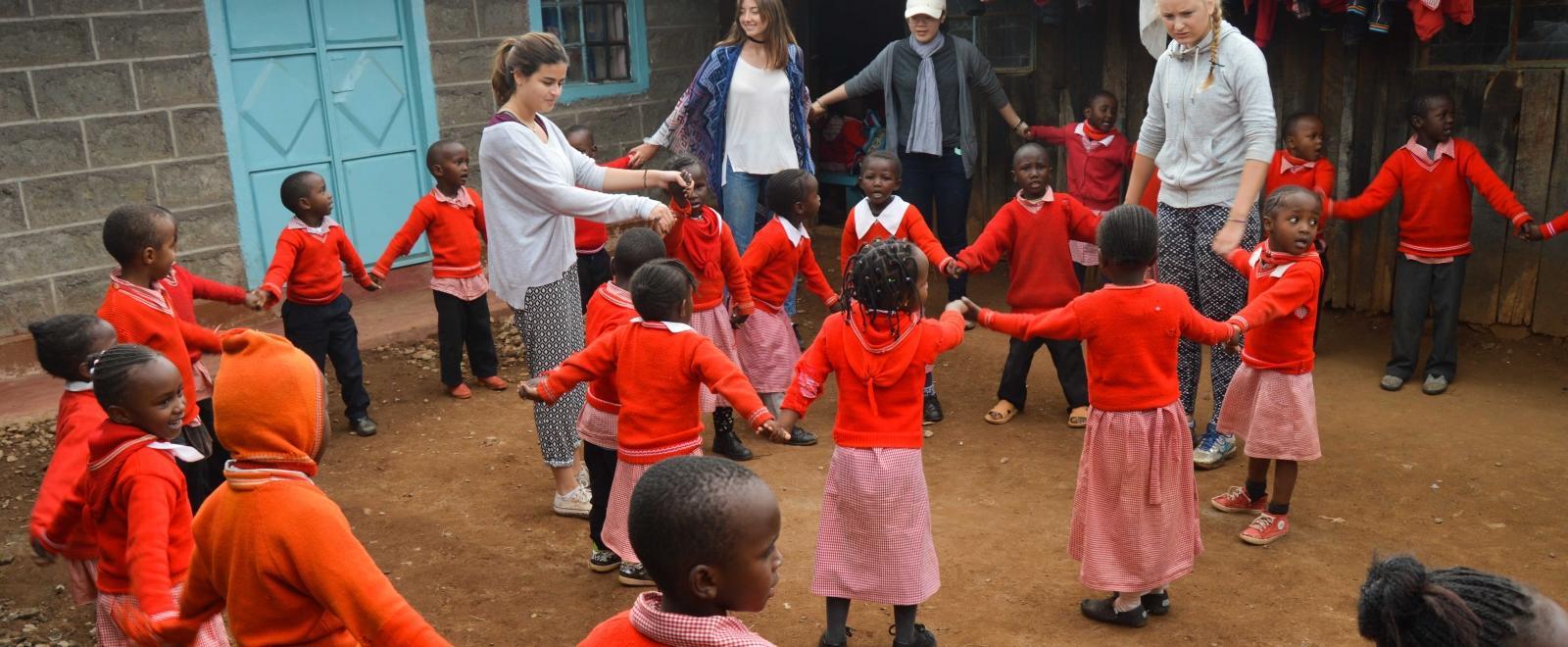 Projects Abroad volunteers assist with childcare volunteering for teenagers in Kenya as they play educational games with the children in the school yard