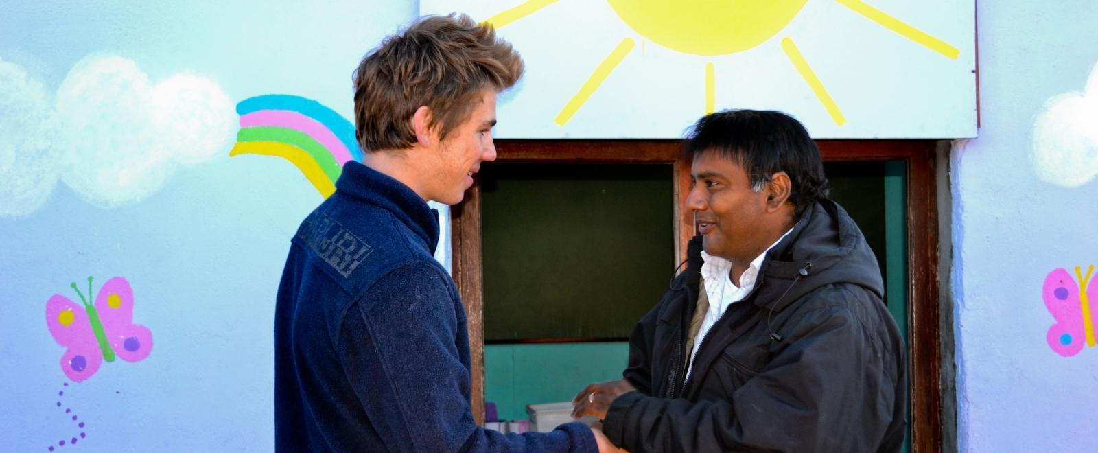 A Projects Abroad project supervisor shakes hands with a volunteer in South Africa.