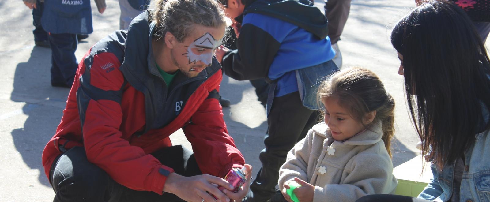 Projects Abroad volunteers interact with a child in Argentina during a community day at a local care centre.