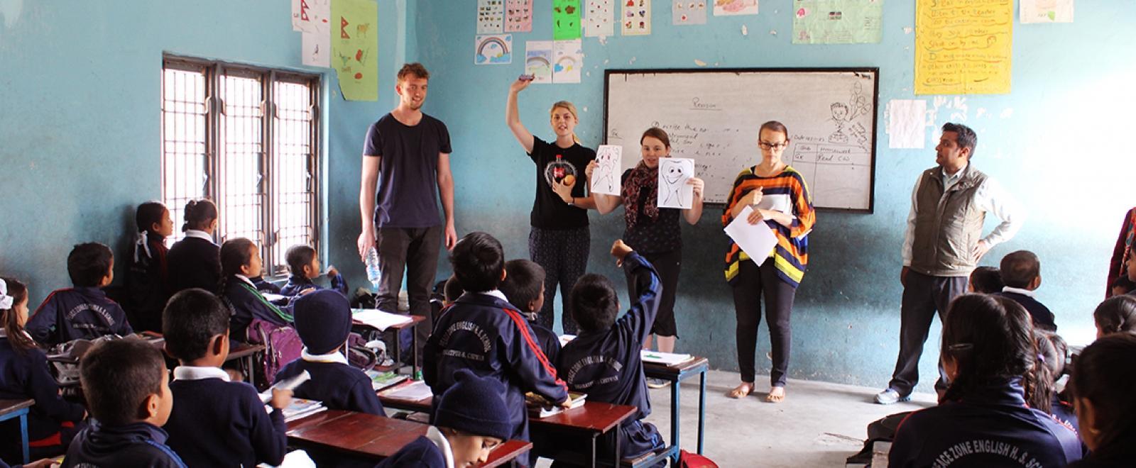 A group of Childcare volunteers team up to help children learn about good dental hygiene in Nepal, Asia. 