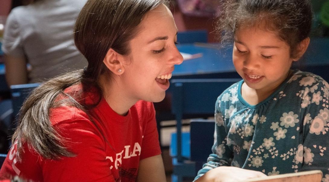 A volunteer reads a book to a young girl at a volunteer teaching placement in Costa Rica