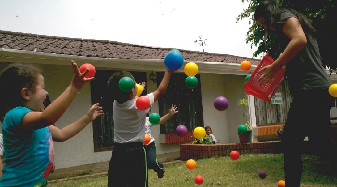 Volunteers and the children play with colourful balls as part of their Childcare volunteer work in Costa Rica