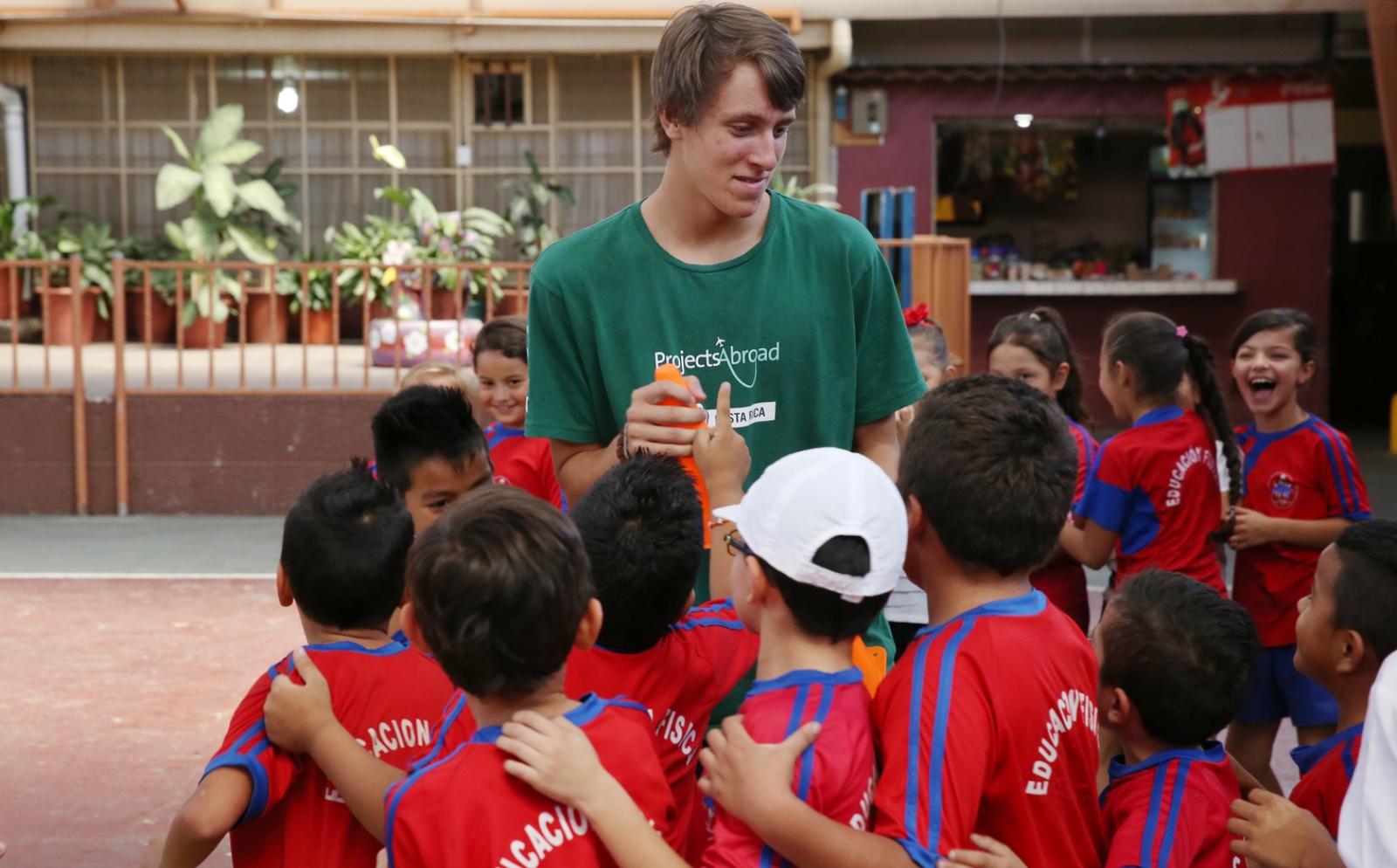 Children in Costa Rica around a Projects Abroad volunteer during a sport practice