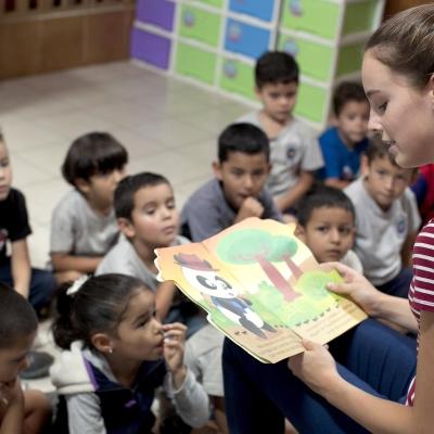 Childcare and Conservation volunteer reads a story to the children in her class