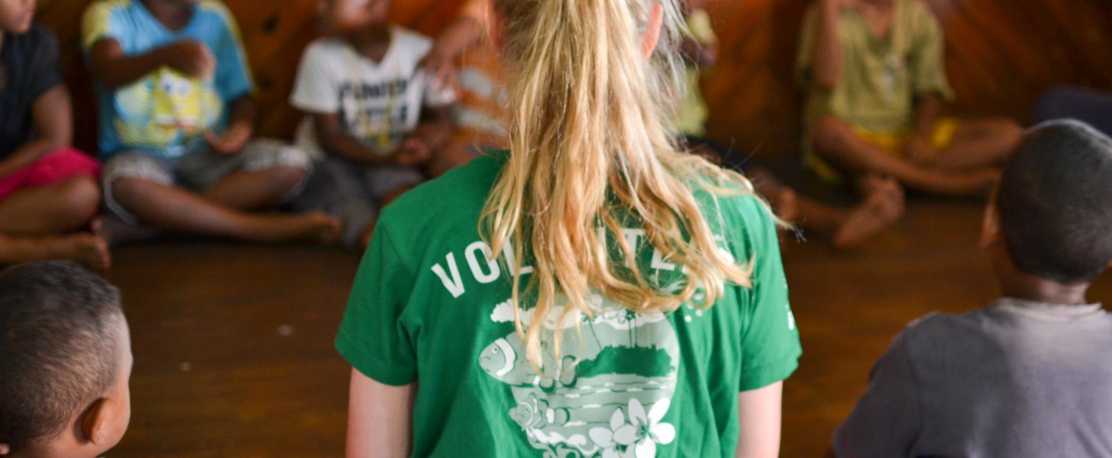 Childcare volunteer sits with her class in Fiji during her volunteer project abroad