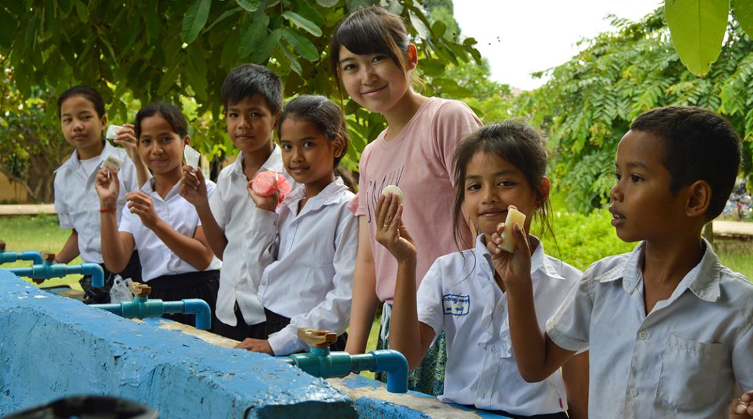 Projects Abroad volunteer working with children teach them how to properly wash their hands.