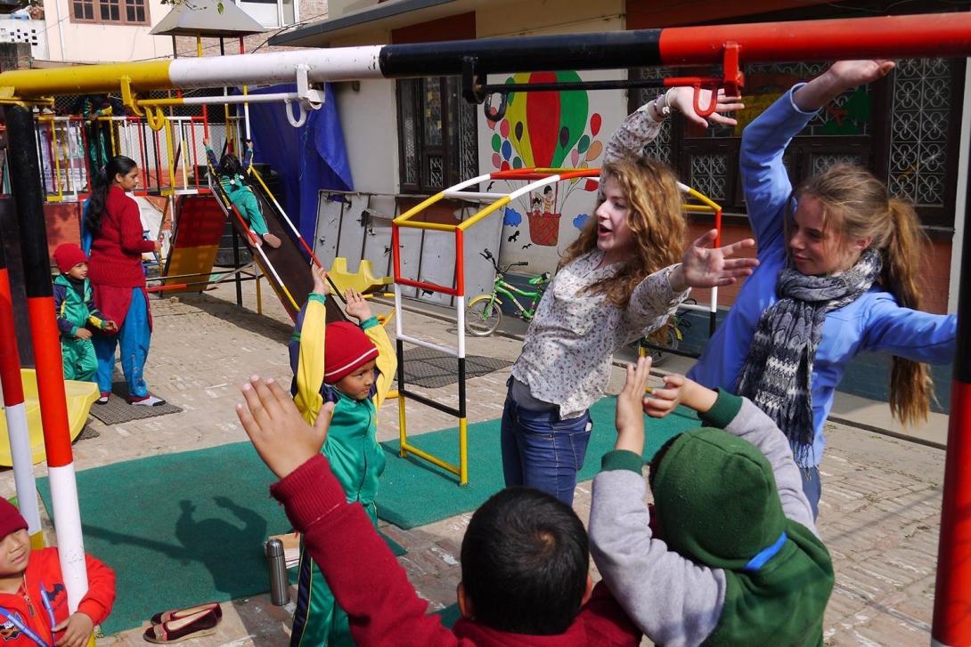 High school student volunteers teaching children activties at a Care center in Patan, Nepal