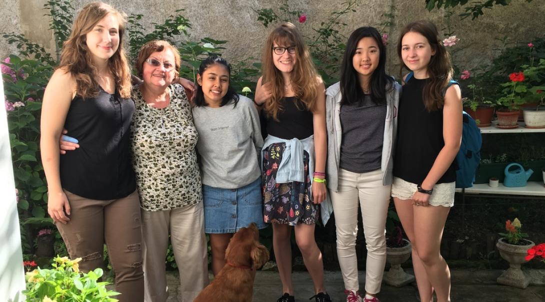 Projects Abroad volunteers take a group photo with their host mother in Romania.