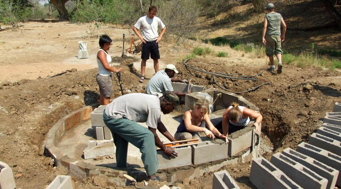 Teenage volunteers working on wildlife conservation by building water holes.