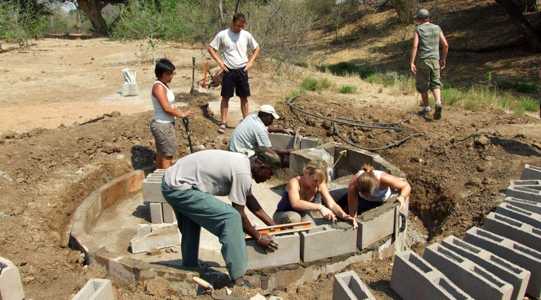 Projects Abroad conservation volunteers build a water hole in the reserve in Kenya for Lions, Giraffes and other animals.