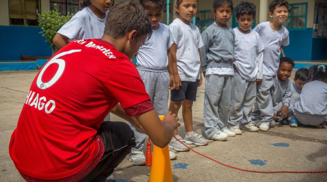 A volunteer sports coach prepares an outdoor activity for kids during his gap semester abroad in the Galapagos Islands.