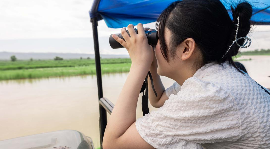 A wildlife volunteer in Nepal spotting animals