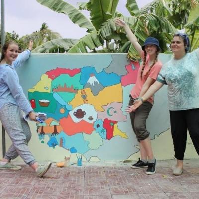 Volunteers showing their painting on a Kindergarten wall in Cambodia